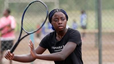 Girl holding a tennis racket.