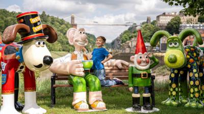 Freddie Hine-Haycock, 6, greets Wallace & Gromit sculptures unveiled as part of the Gromit Unleashed 2025 trail in Bristol.