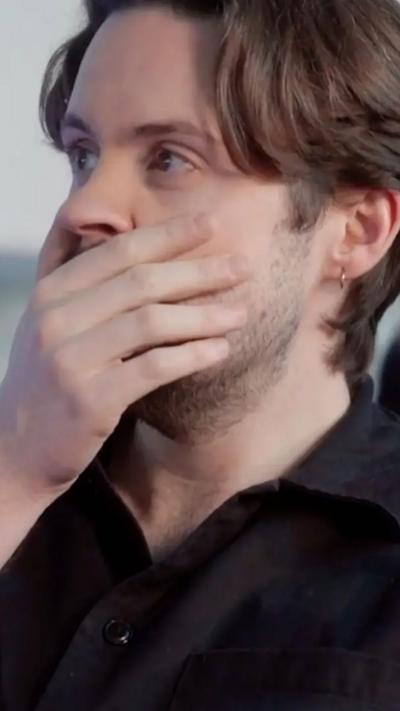 A man with short, brown hair covers his mouth with his hand
© BBC