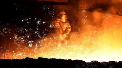 A melter puts sand on flowing steel at a furnace of German steel technology group Salzgitter