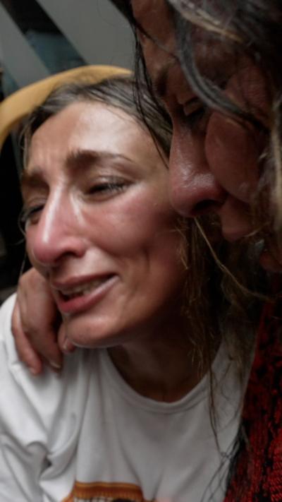 Aida abu Rob crying as woman holds her in her arms