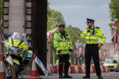 Two police officers in London and a police motorcycle standing guard