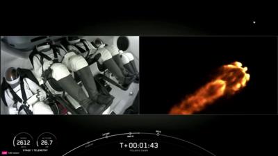 Astronauts sit in cockpit as rocket launches