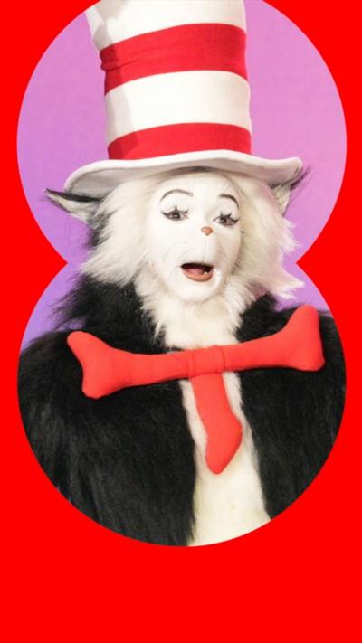 A man in a furry cat costume. He is wearing a red and white striped hat, and a red necktie.