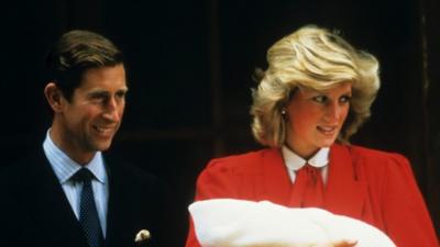 Prince Charles and Princess Diana holding newly born Prince Harry