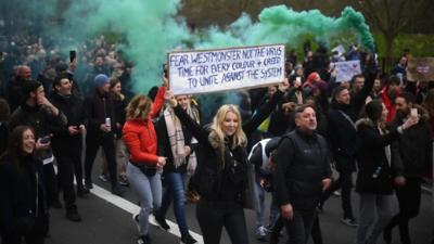 Anti-lockdown protesters march in London carrying placards