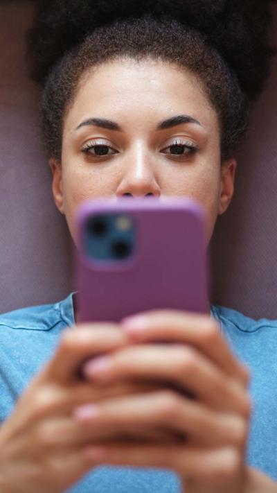 A woman holds a purple phone with both hands
