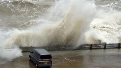 Car beside waves.