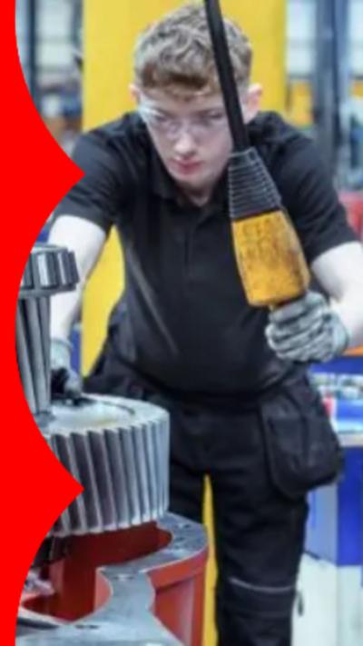 A young man with wavy blond hair wearing safety goggles and using machinery.
