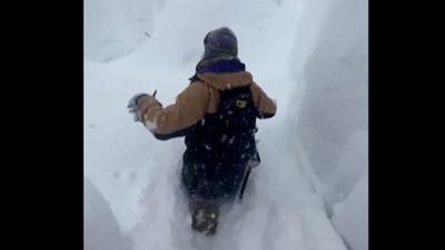 Man in waist-high snow in California