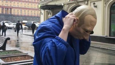 Russian protester Roman Roslovtsev wearing a Vladimir Putin mask