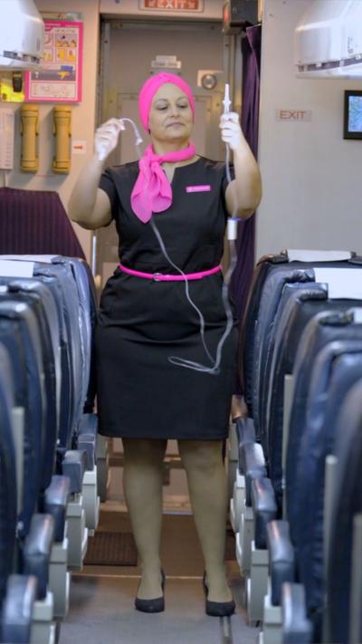 Woman stood on plane in flight attendant clothes