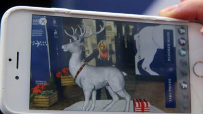 A smartphone showing Lara Lewington looking at an augmented reality image of a reindeer