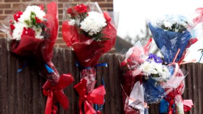 Flowers tied to fence