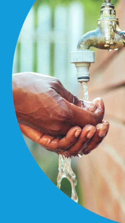 Cropped shot of an unrecognizable woman washing her hands under a garden tap