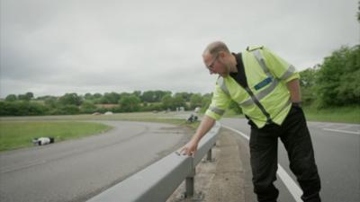 man pointing at abrasive mark on a barrier 
