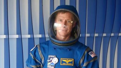 A man wearing a blue spacesuit