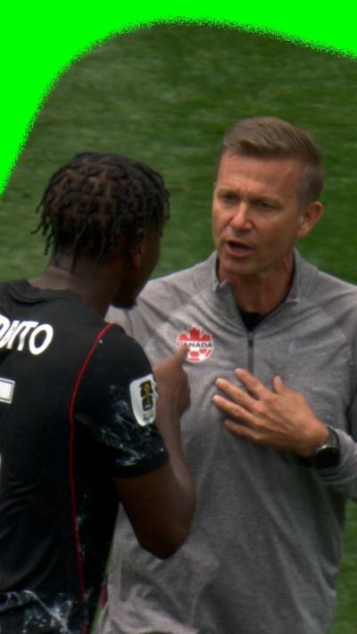 Canada manager Jessie Marsch being held back by his player Moïse Bombito at half-time at the 2026 World Cup