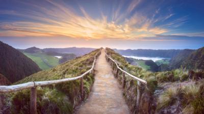 A path leading through a beautiful countryside landscape featuring a lake