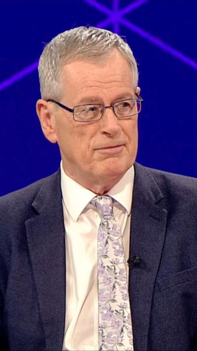 Prof Jonathan Tonge in a dark suit wearing a pale floral tie 