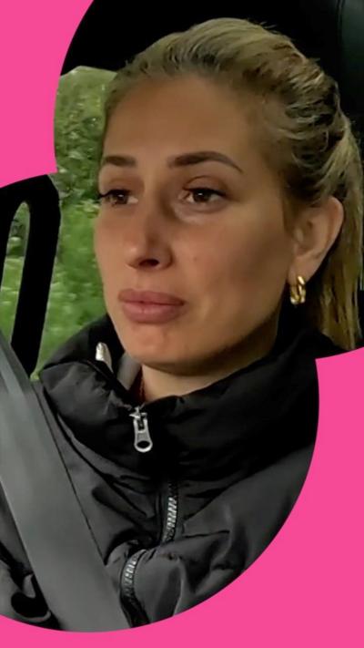 Stacey wears a black jacket aas she drives a car.