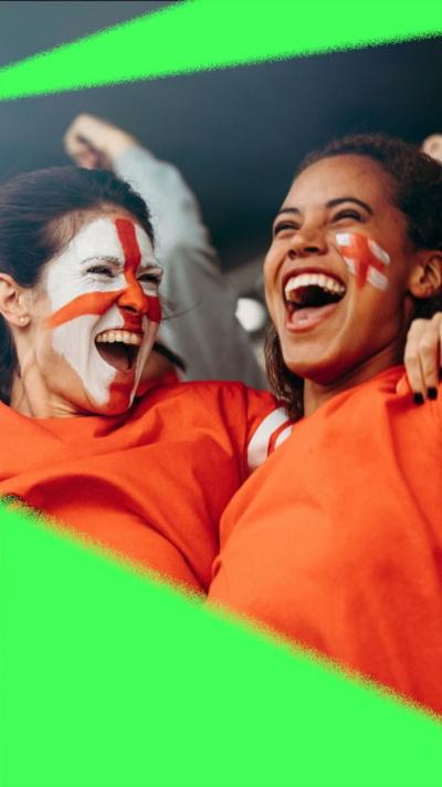 Two women with face paint in the colours of England cheering and hugging