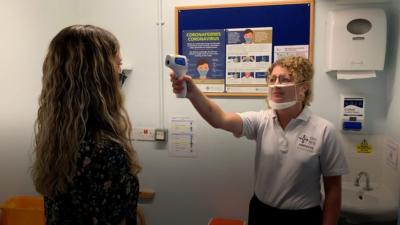 An audiologist wearing a clear face mask