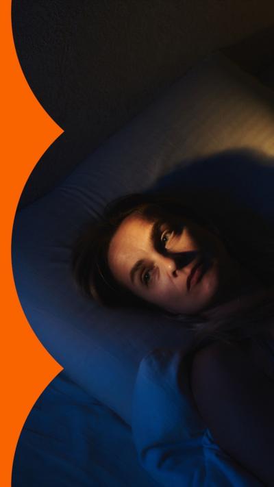 A woman lies awake in bed