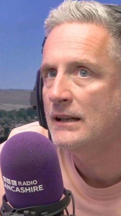 Man with short grey hair wearing headphones
