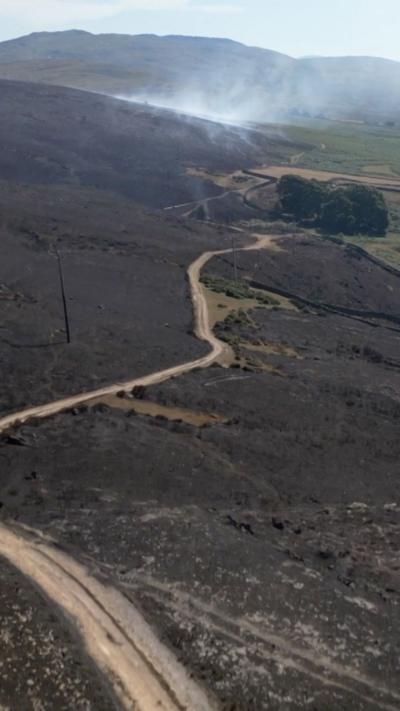 An aerial view of a scorched landscape with a path going through it 