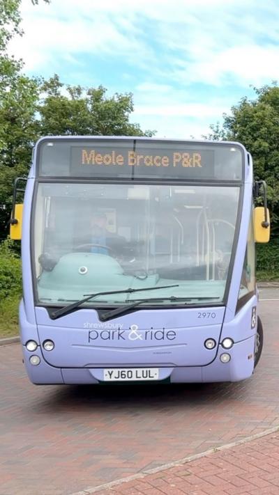 A violet coloured single decker bus. The bus sign says Meole Brace P&R