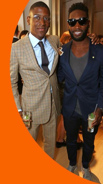 The DJ Labrinth stands with his arm around fellow DJ Tinie Tempah. They both smile at the camera.