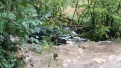 A car being swept down a river