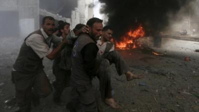 A injured man is carried in Douma