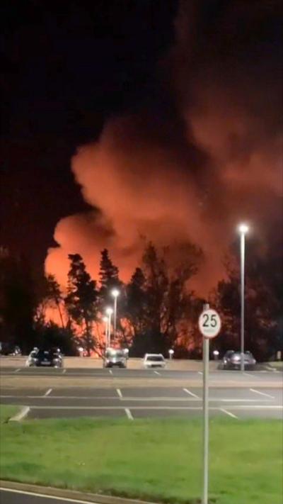 Smoke rising from a warehouse, filmed at night