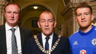 Northern Ireland manager Michael O'Neill and captain Steven Davis are greeted by Belfast Lord Mayor Arder Carson at a civic reception in Belfast City Hall