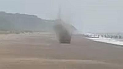 Mortar exploding on a beach.