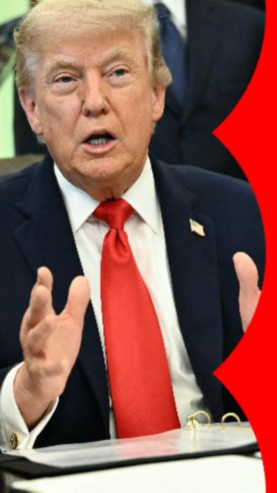 Donald Trump sat behind a desk with his hands out in front of of him.