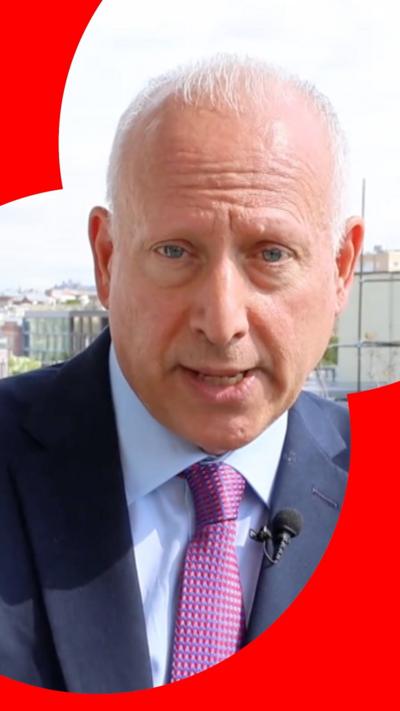 Steve Rosenberg in a suit with the skyline behind him on a sunny day