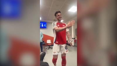 Declan Rice wearing an Arsenal kit in a changing room