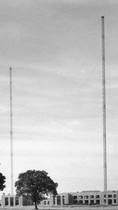 black and white photo showing two transmitters either side of a building