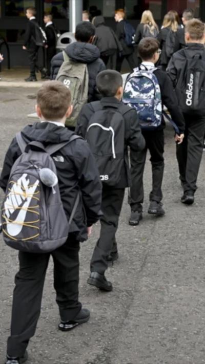 A line of children make their way into school