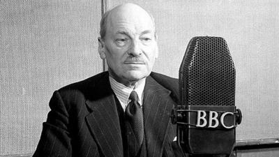 Clement Attlee sits behind a BBC microphone