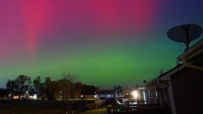 The northern lights can be seen as a greenish haze in the evening sky over Toronto.  