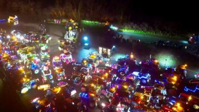 hundreds of tractors light up like christmas trees on a field