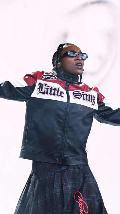 Little Simz wears a leather jacket with her nam on the from and sunglasses as she performs at Glastonbury 2024
