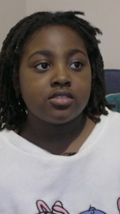 Girl sat on a sofa in a white top