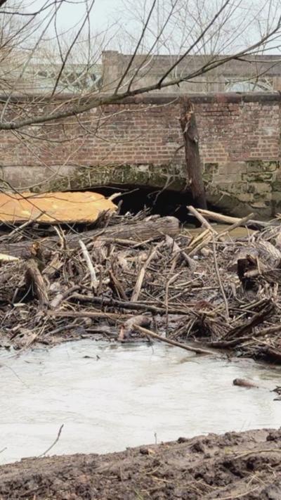 Wood and debris against a river bridge