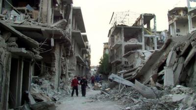 Young Syrian men surrounded by rubble in Homs, file pic from 29 Nov 2012