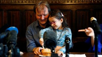 Nazanin's daughter cuts a "welcome home" cake with her dad